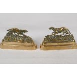 A pair of C19th brass book ends cast as stalking dogs, 8" long