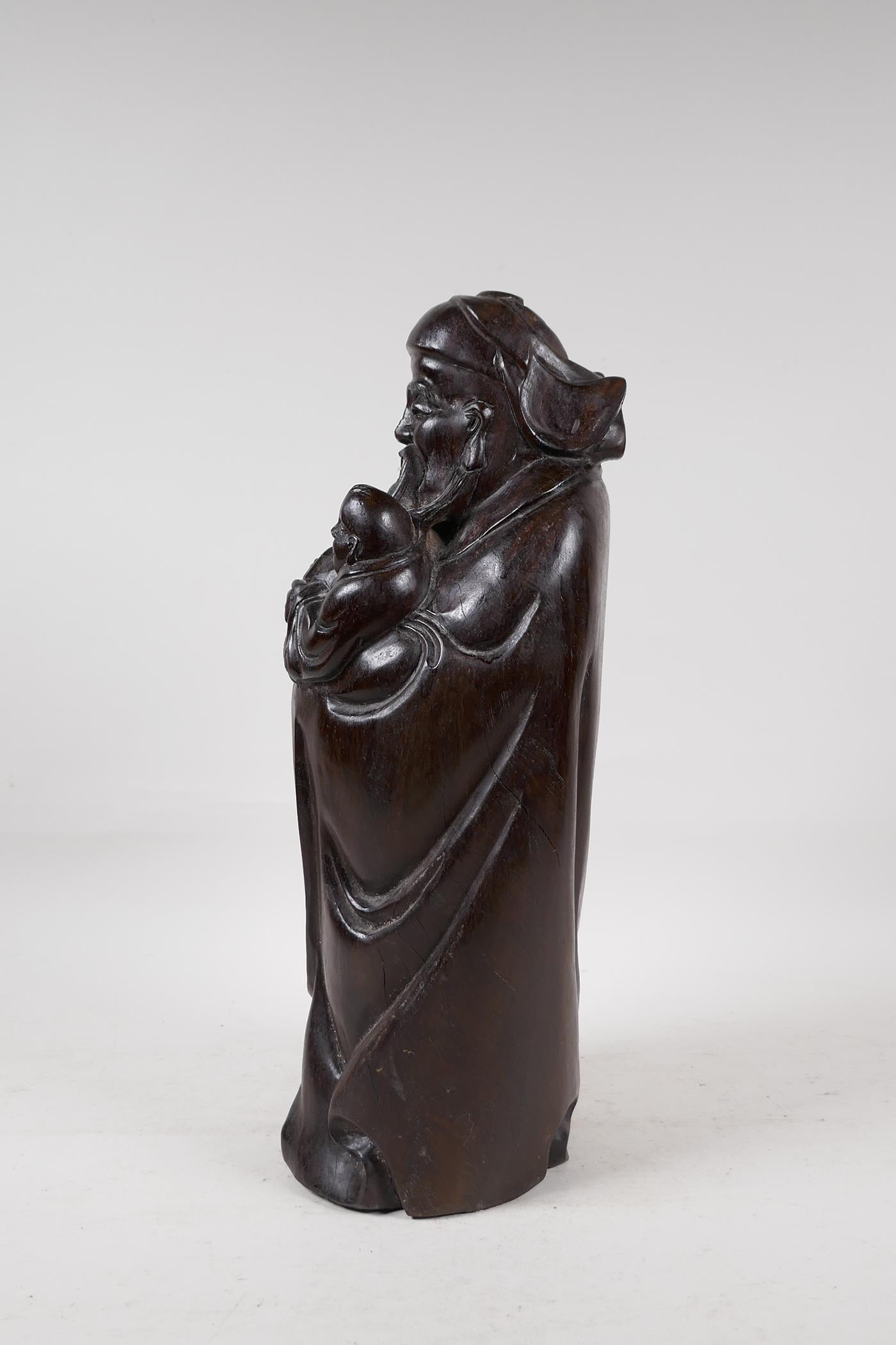 A Chinese carved hardwood figure of a sage carrying a child, 15" high - Image 3 of 5