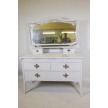 An Edwardian painted dressing table, with carved details, the mirrored top section with two drawers,