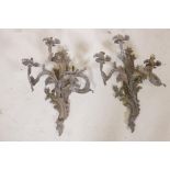 A pair of rococo style gilt brass three branch wall sconces, with verdigris patination, 19" long