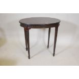 An Edwardian Adam style mahogany oval shaped occasional table, with reeded frieze and carved