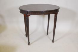 An Edwardian Adam style mahogany oval shaped occasional table, with reeded frieze and carved