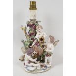 A Naples porcelain figural lamp base modelled as three cherubs drinking from a barrel, 10" high, A/F
