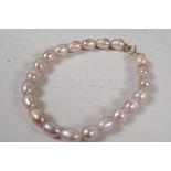 A cultured pearl bracelet with 9ct gold clasp, 7" long