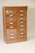 A 1920s walnut flight of sixteen drawers, arranged in two banks of eight, 27½" x 16", 44" high