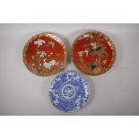 A pair of Japanese red ground pottery cabinet plates with satsuma decoration depicting birds amongst