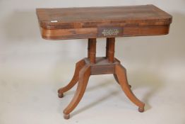 A Regency brass inlaid rosewood card table, raised on ring turned columns, platform base and splayed