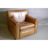 A continental leather club chair with brass studs, 34" x 36", 33" high