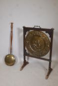 An antique brass charger mounted in an oak screen frame with repousse decoration of a husband and