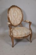 An early C19th walnut show frame open arm spoon back chair with carved back and front rail, raised