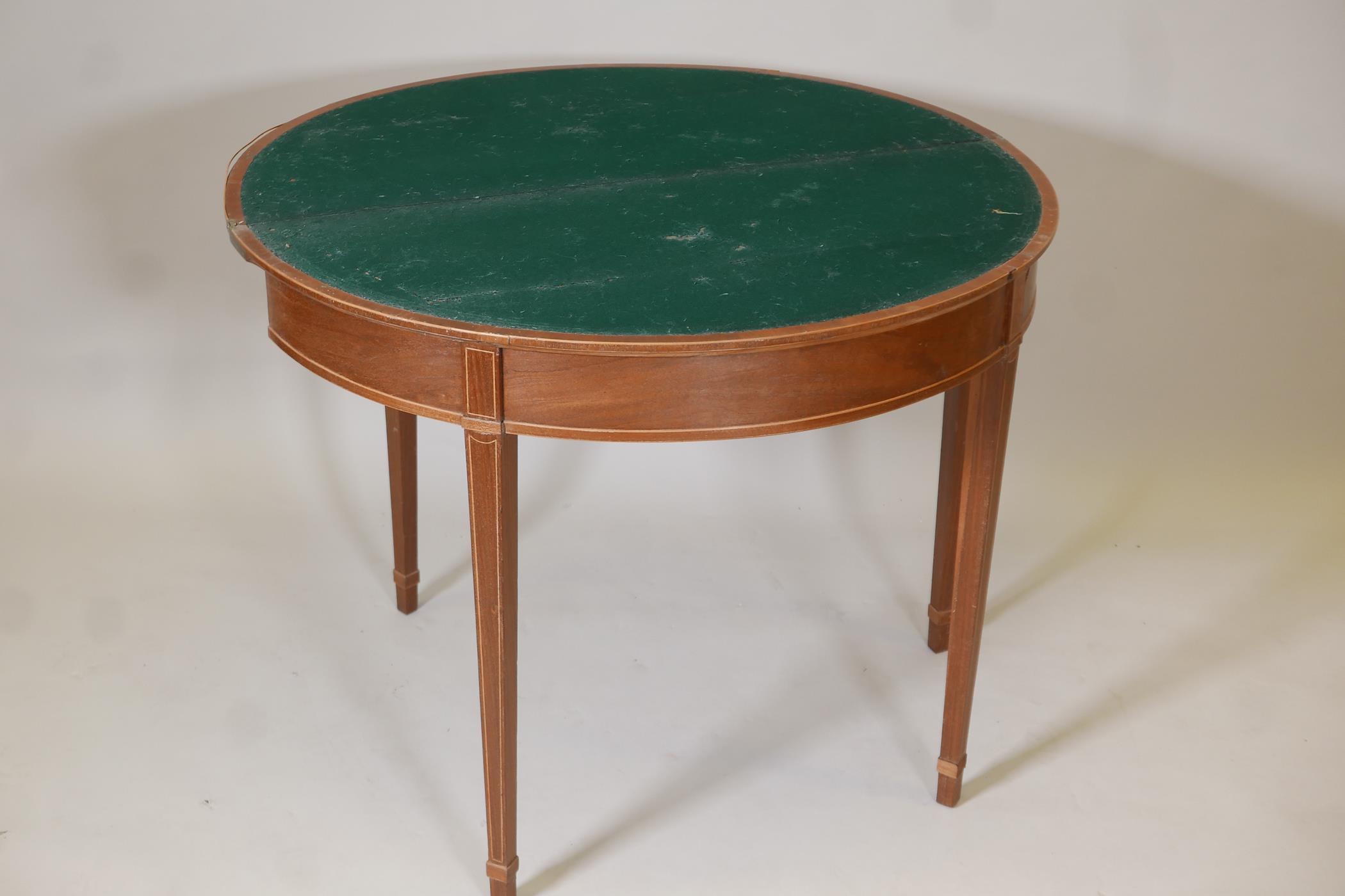 A Regency inlaid mahogany demilune card table with a marquetry top, raised on square tapering - Image 4 of 4