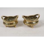 A pair of Chinese polished bronze incensors with loop handles and engraved bodies, 4" diameter
