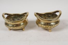 A pair of Chinese polished bronze incensors with loop handles and engraved bodies, 4" diameter