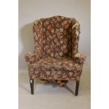 A Georgian wing back armchair with scroll end arms, raised on square tapering mahogany supports, A/F