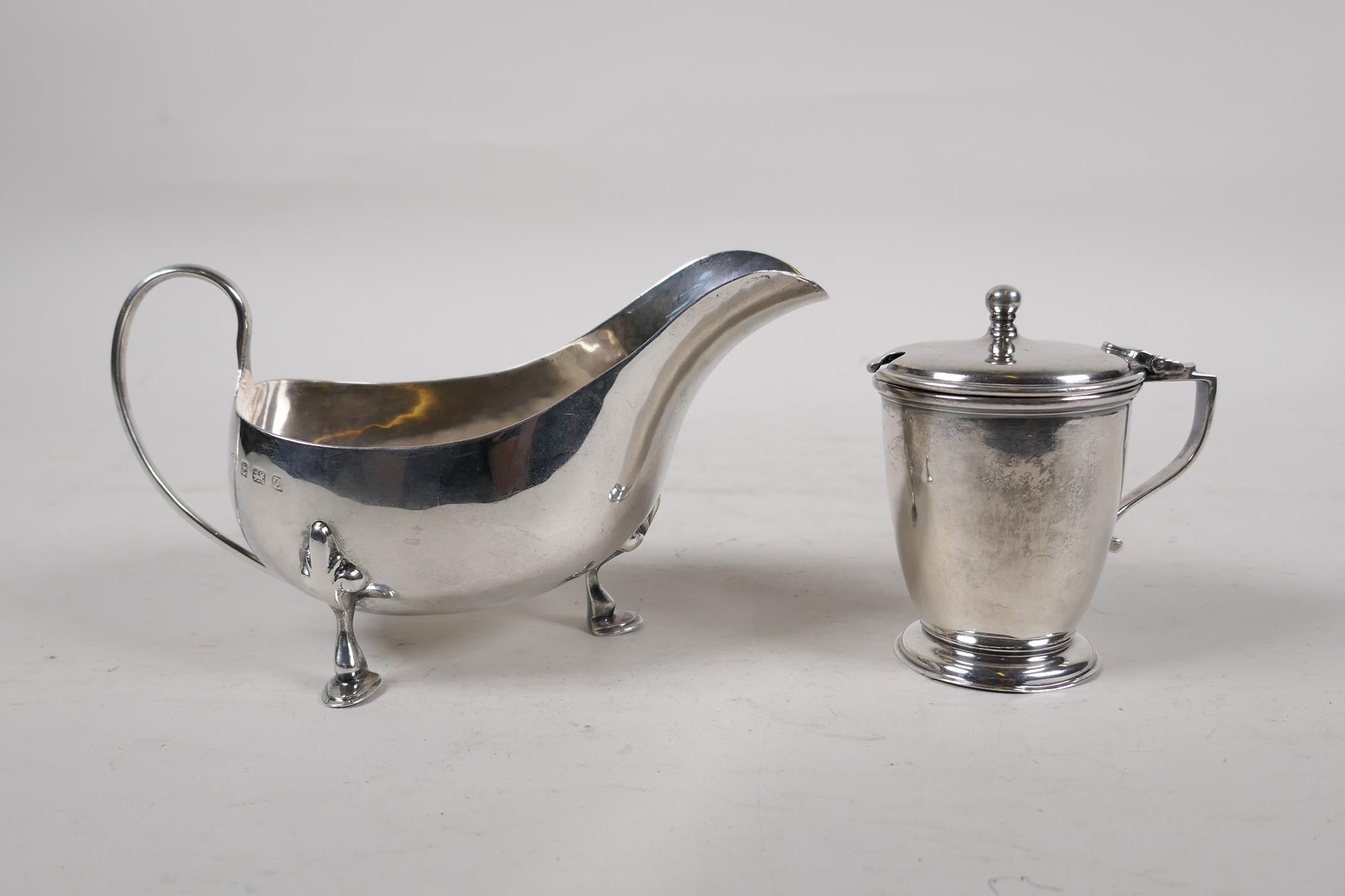 A hallmarked silver sauce boat, Birmingham 1924, and a silver mustard pot with blue glass liner,