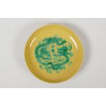 A Chinese yellow ground porcelain saucer decorated with green incised dragons, six character mark to