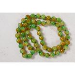 A string of 60 two colour jade beads, 32" long