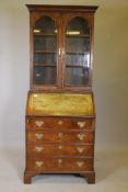 A C19th walnut bureau bookcase on bracket fee, the fall front fitted with drawers and pigeon holes