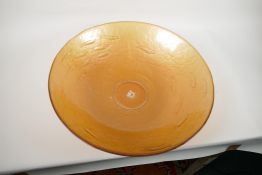 A large amber glass centrepiece bowl, embossed with a shoal of fish, 19" diameter