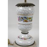 An urn shaped porcelain table lamp with ormolu mounts and painted with garlands of flowers, on a