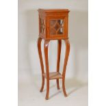 An early C20th Danish inlaid solid satinwood pedestal display stand and curio cabinet, on carved