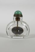 A Chinese glass snuff bottle containing a brass coin, 2" high