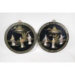 A pair of lacquered chinoiserie plaques with inlaid decoration of female travellers, 16" diameter