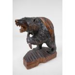 A Black Forest carved wood figure of a brown bear with a salmon, 11" high