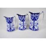 A set of three graduated Art Nouveau blue and white pottery jugs with gilt embellishments from F &