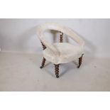 A C19th bow shaped nursing chair raised on bobbin turned supports