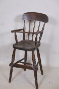 A C19th child's beechwood correction chair with elm seat, A/F footrest detached