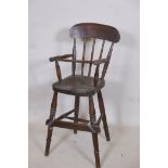 A C19th child's beechwood correction chair with elm seat, A/F footrest detached