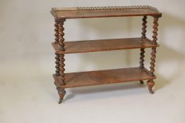 A Victorian figured walnut three tier open shelf, the top with three quarter pierced brass