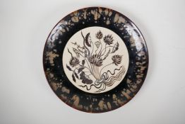 A Chinese Cizhou kiln pottery charger decorated with a lotus flower spray, 13½" diameter