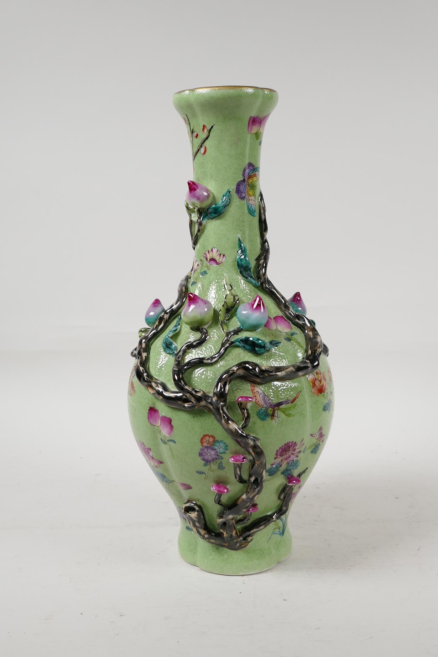 A Chinese polychrome porcelain vase with applied peach tree decoration on a green ground, seal