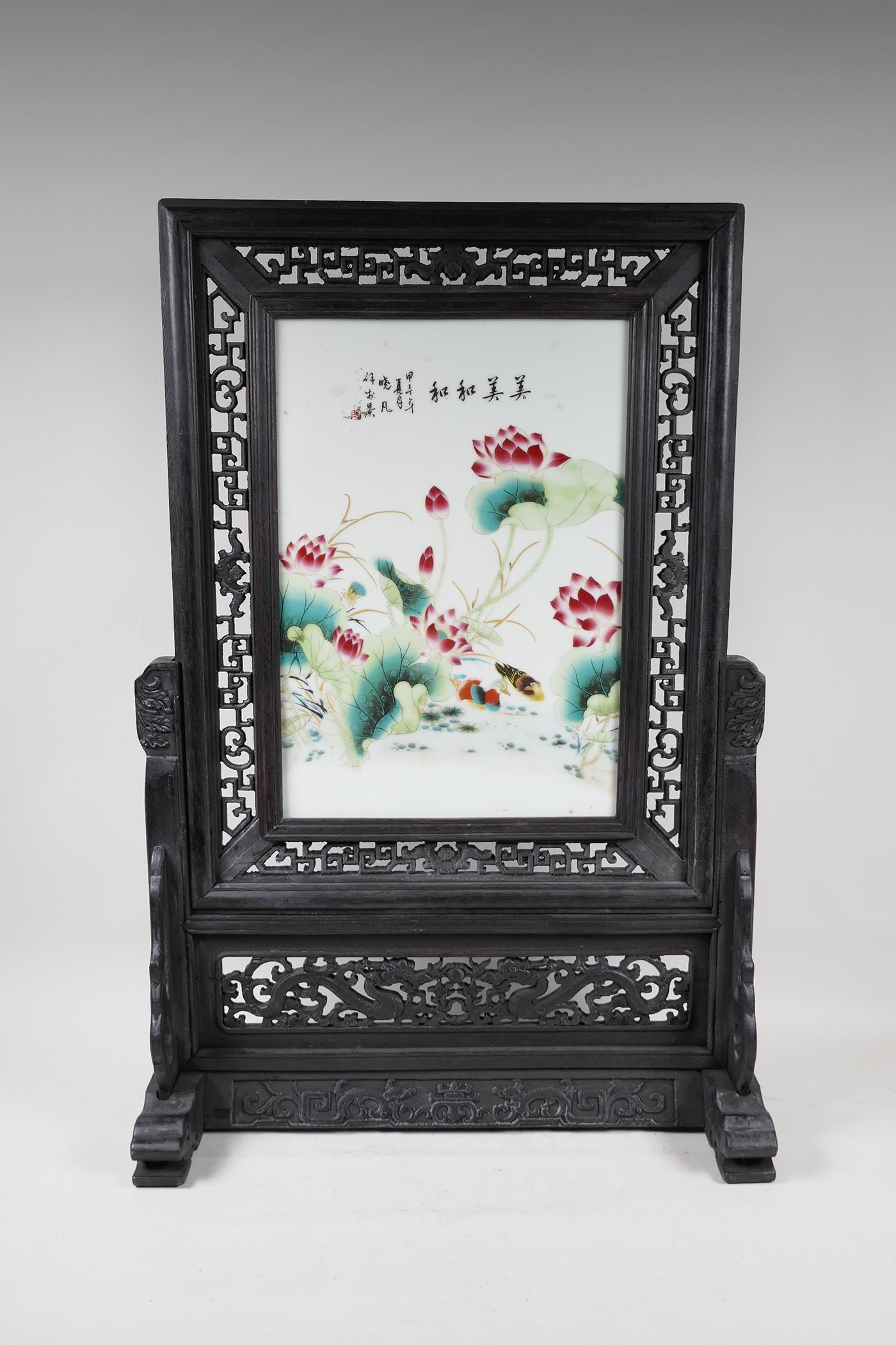 A Chinese polychrome porcelain table screen in a hardwood frame, decorated with waterfowl beneath