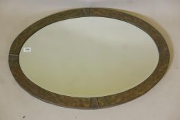 An Arts & Crafts hammered metal wall mirror with copper details and bevelled glass, 34" x 24"