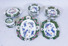 A Masons ironstone part dinner service decorated with Imari style flowers within a green border,