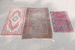 A Persian hand woven black and rust ground wool rug, the central field with a quartered geometric