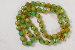 A string of 60 two colour jade beads, 32" long