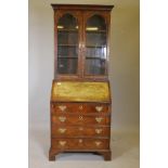 A C19th walnut bureau bookcase on bracket fee, the fall front fitted with drawers and pigeon holes