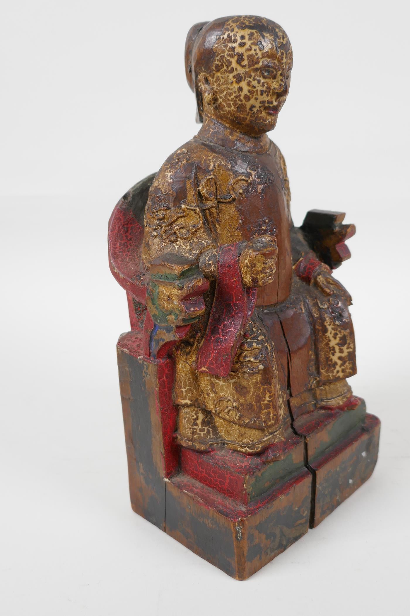 A Chinese carved wood figure of a dignitary seated on a throne, traces of paint, 9" high - Image 2 of 6