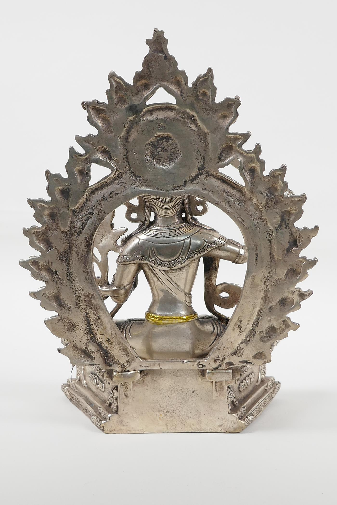 A Sino Tibetan white metal figure of a seated deity carrying a sword with gilt highlights, double - Image 3 of 5