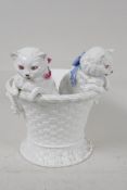 A continental porcelain jardiniere modelled as two kittens in a basket, 7½" high