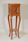 An early C20th Danish inlaid solid satinwood pedestal display stand and curio cabinet, on carved