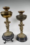 Two table lamps, the central bronze columns cast as two cherubs supporting an urn, with brass oil