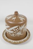A C19th pottery stilton dish and cover, decorated with white Jasperware style fern fronds on a brown
