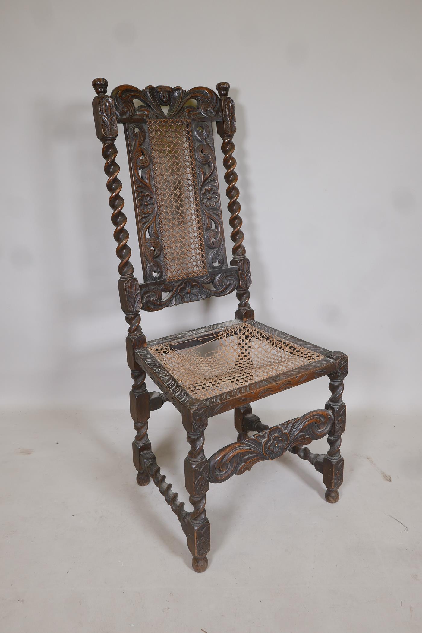 A late C18th/early C19th oak barleytwist chair with a cane seat and back, and carved floral details,