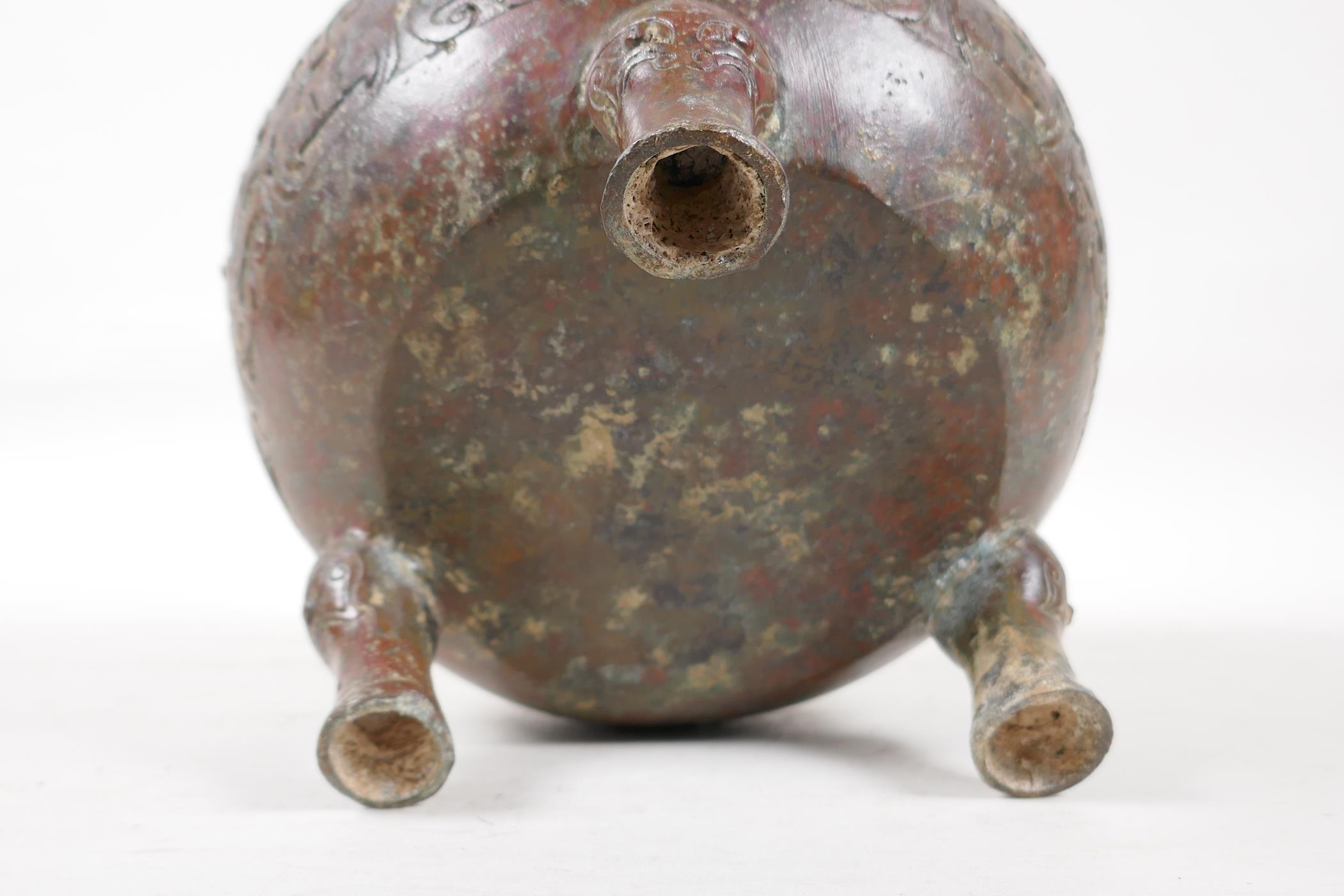 A Chinese bronze two handled vase raised on tripod supports, with raised and engraved archaic - Image 6 of 7