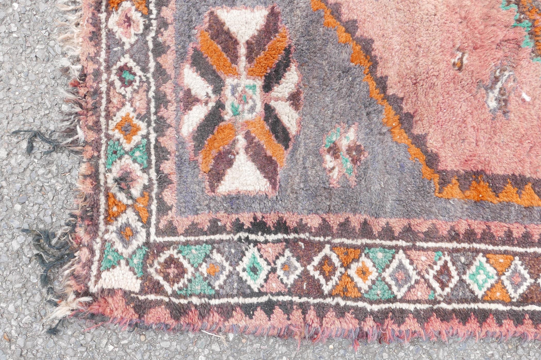 A full pile grey ground Afghan Belouch nomadic rug with pink medallion design and pink border, A/F - Image 3 of 5